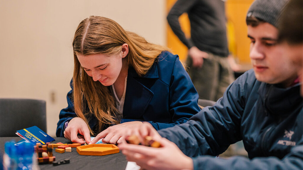 UNCG students work on wood block puzzles together.