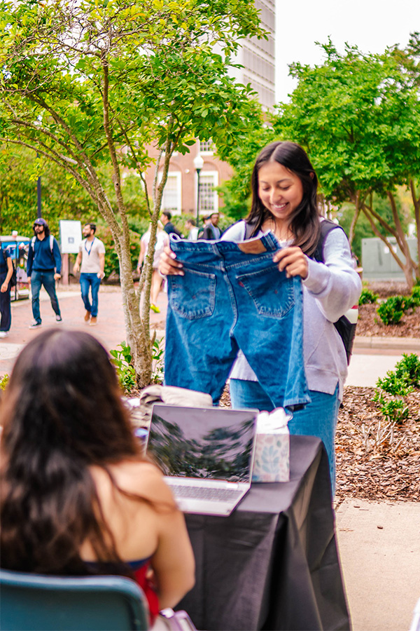 A UNCG student looks a pair of jean shorts sold in the student marketplace.