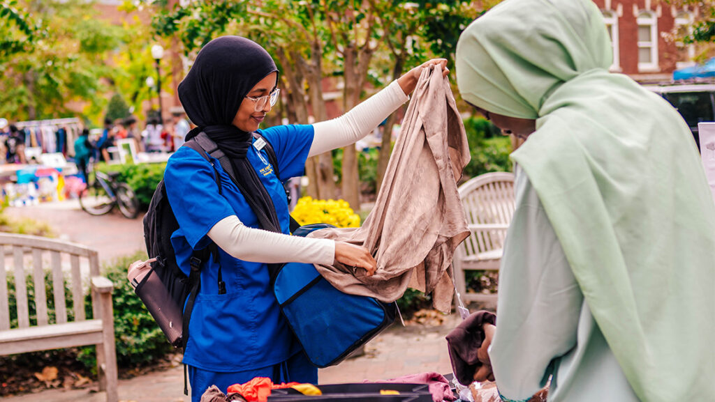 A UNCG student examines a scarf being sold by another student.